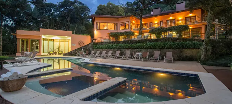Piscina aquecida ao entardecer entre as araucárias